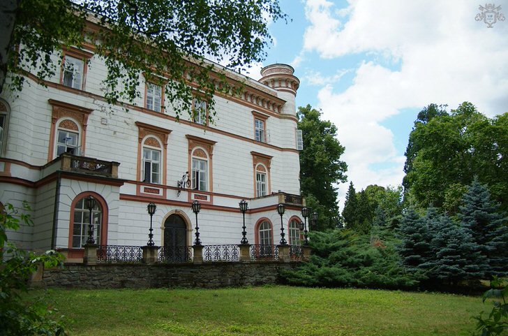Стиль ампир тоже может быть лаконичным и сдержанным. Оформление дома приближено к классическом, но декоративные элементы фасада говорят о присутствии стиля ампир. 