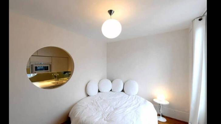 Пустота в стене овальной формы делает небольшую квартиру роскошной студией.