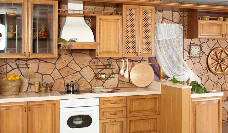 Стильная кухня в деревенском стиле с отделкой стен природным камнем и встроенной техникой.
