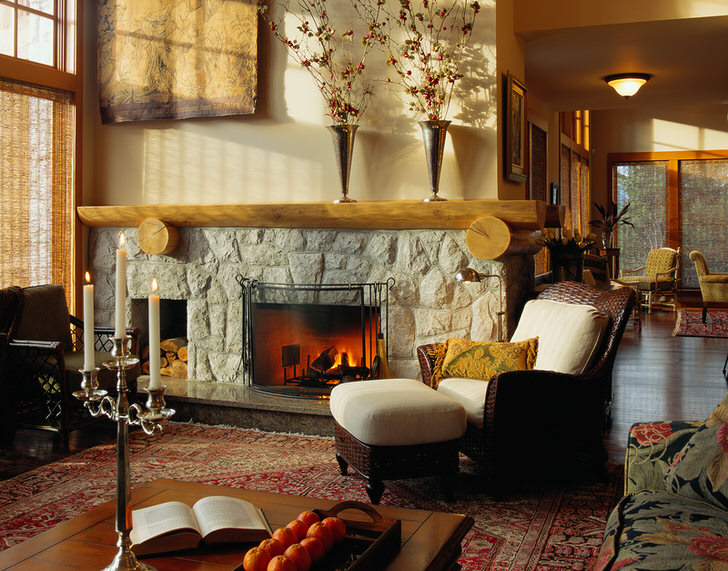 По-семейному теплая и уютная гостевая комната в стиле кантри с мягкой мебелью и внушительным камином из природного камня.
